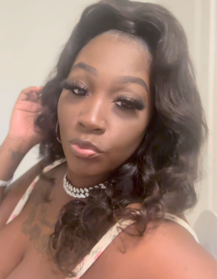 Close-up of a woman with long curly hair and makeup, representing a mom involved in public breastfeeding controversy.