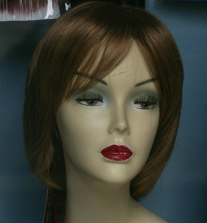 Mannequin head wearing a brown wig with makeup, representing a woman refusing to wear a wig at brother's wedding. Mannequin head wearing a brown wig with makeup, representing a woman refusing to wear a wig at brother's wedding.
