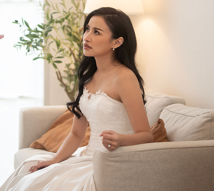 Woman sitting in wedding dress looking upset, reflecting refusal to wear a wig at brother's wedding. Woman sitting in wedding dress looking upset, reflecting refusal to wear a wig at brother's wedding.
