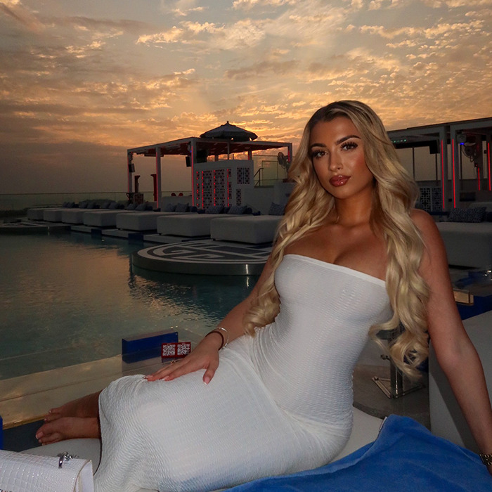 Young woman in white dress by pool at sunset, related to Dubai prison and UAE moving warnings. Young woman in white dress by pool at sunset, related to Dubai prison and UAE moving warnings.