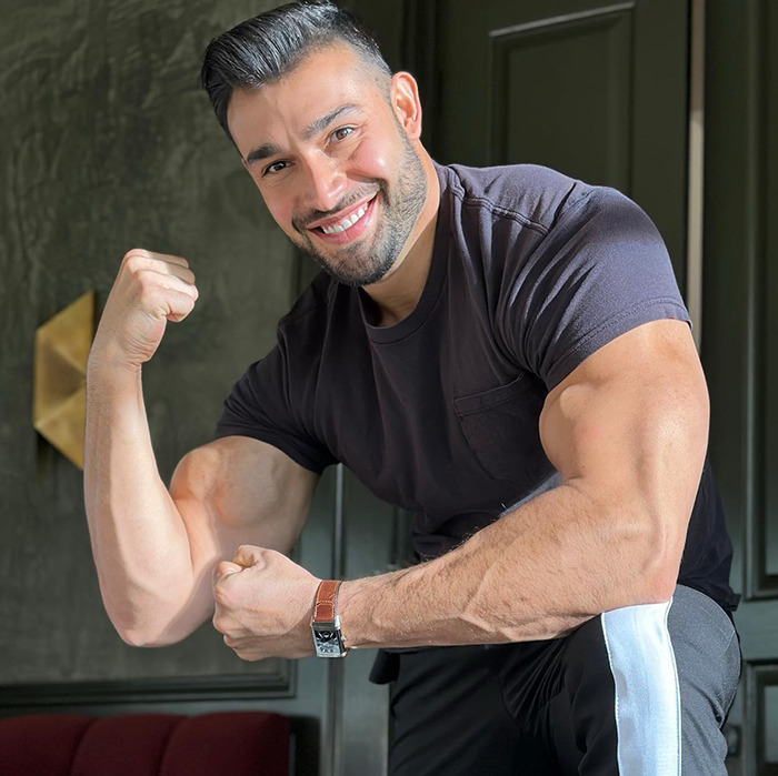 Sam Asghari flexing muscles and smiling during workout, Britney Spears fans notice that 3rd leg detail in video.