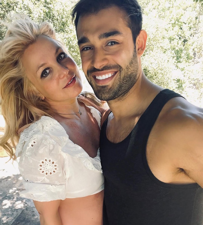 Britney Spears and Sam Asghari smiling outdoors, fans spot x-rated detail in ex Sam Asghari's workout video.