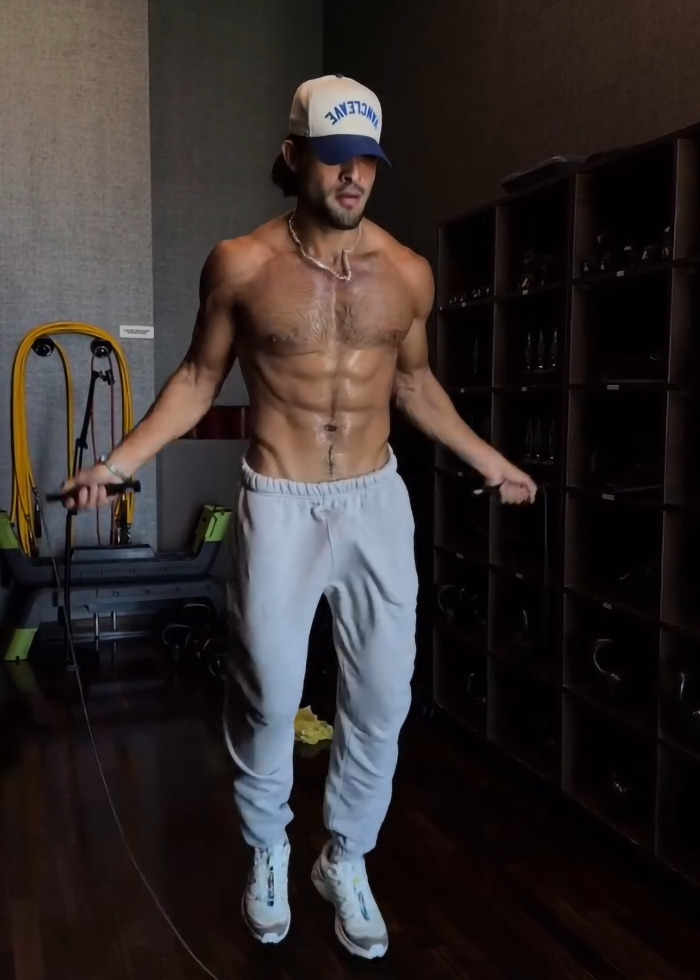 Sam Asghari shirtless jumping rope in gym, showcasing muscular physique and fitness routine details spotted by Britney Spears fans.