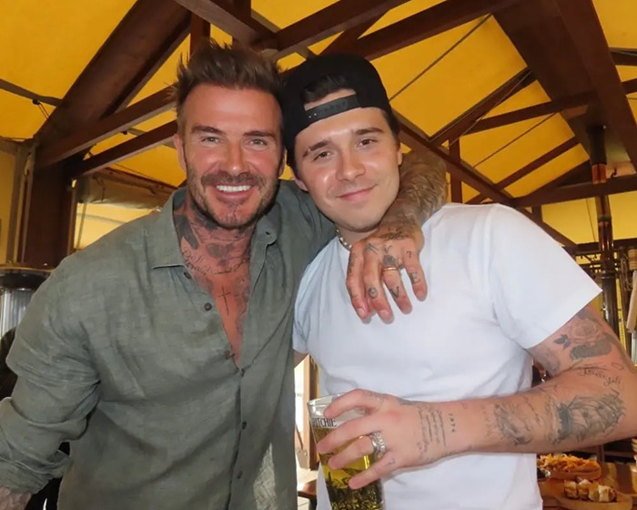 David Beckham smiling with a friend in a casual setting, highlighting rumored family feud and narcissistic label.