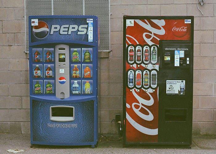 Two vintage soda vending machines side by side, highlighting things people can't believe they had to explain.
