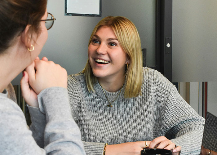 Two adults having a lively conversation in a cozy setting, illustrating things people can't believe they had to explain.