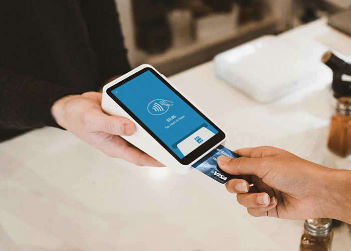 Person using a contactless card reader and Visa card, illustrating things people can't believe they had to explain to another adult.