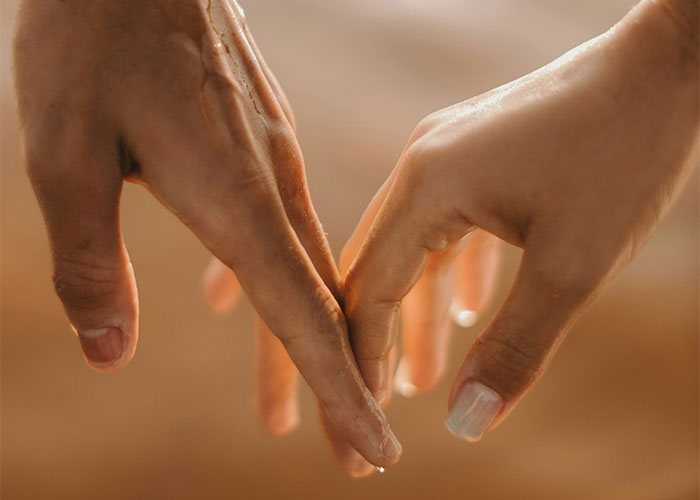 Two hands gently touching fingers, illustrating connection in moments people can't believe had to explain to another adult.