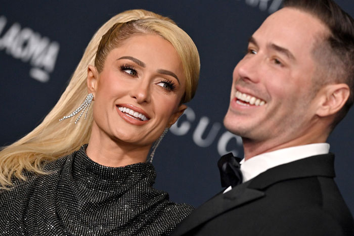 Paris Hilton and Carter Reum in formal attire smiling at an event, highlighting Carter Reum&rsquo;s fortune and M13 Ventures growth.