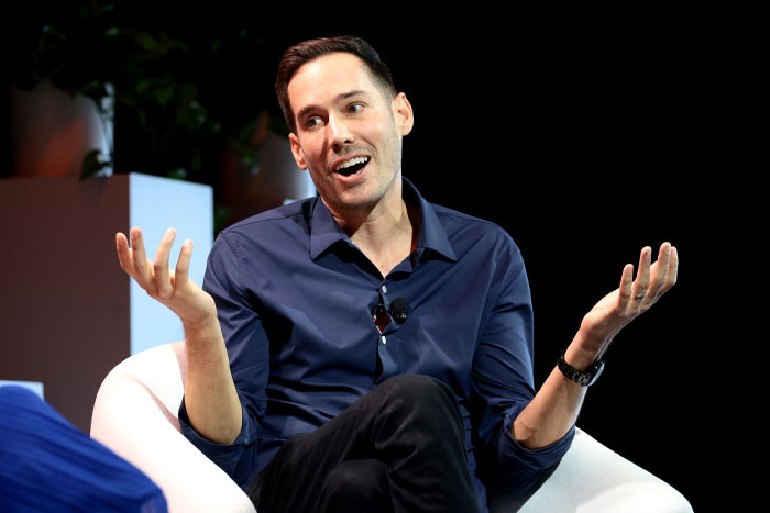 Carter Reum in a blue shirt gesturing with hands during a discussion about Carter Reum&rsquo;s fortune and M13 Ventures growth.