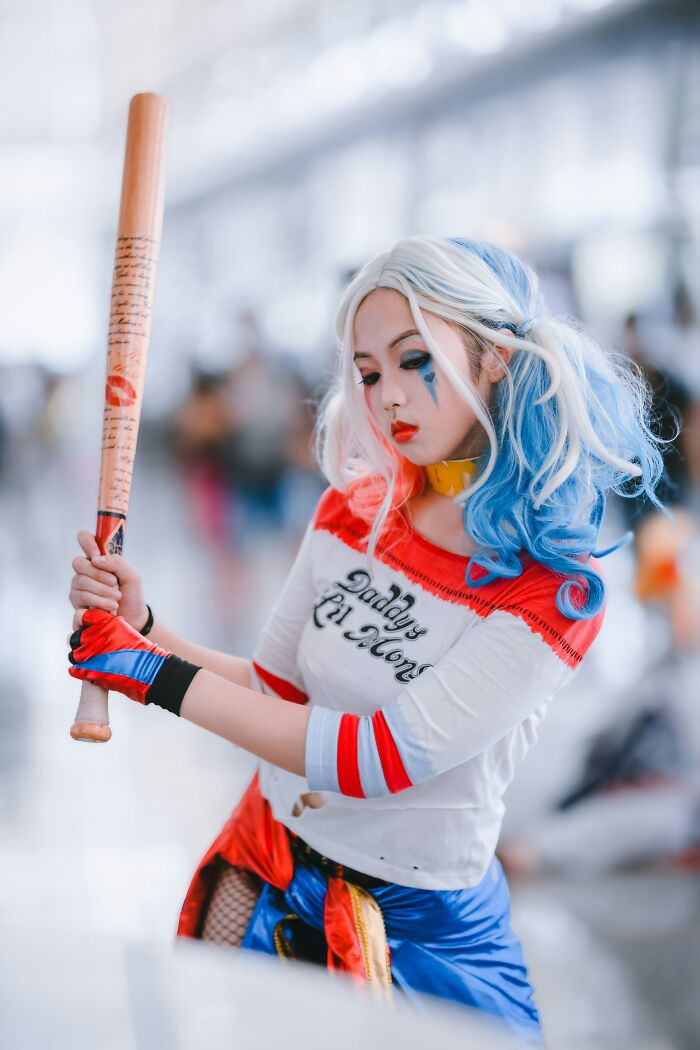 Cosplayer posing with a baseball bat in colorful costume illustrating cashiers judge customers for buying concept.