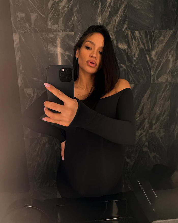 Cassie Ventura taking a mirror selfie in black off-shoulder top with long dark hair in a marble-tiled room. Cassie Ventura taking a mirror selfie in black off-shoulder top with long dark hair in a marble-tiled room.