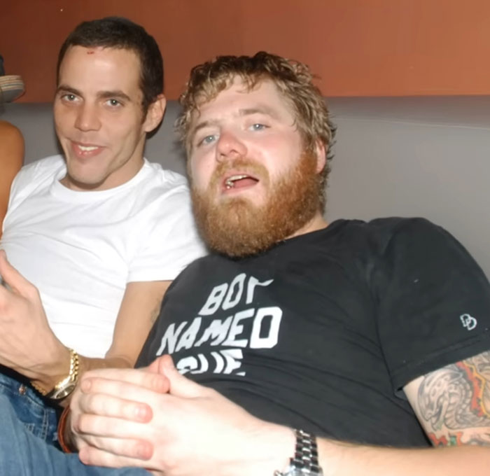 Two men casually sitting on a couch revealing celebrities before their fame struck in a candid moment between netizens.