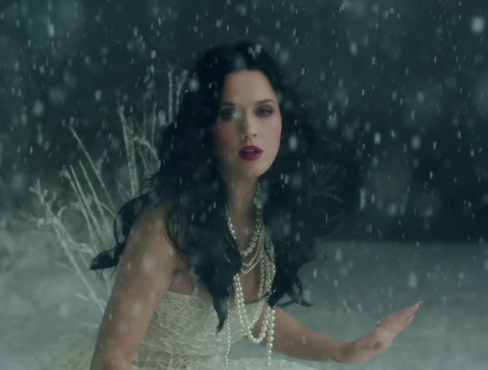 Woman in a white dress with pearls standing in falling snow, illustrating celebrities before their fame as shared by netizens.