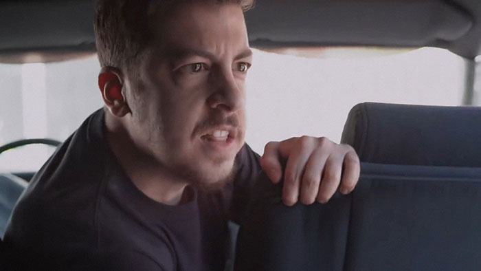 Man leaning forward inside a car, portraying intensity, relating to netizens who knew celebrities before fame struck.