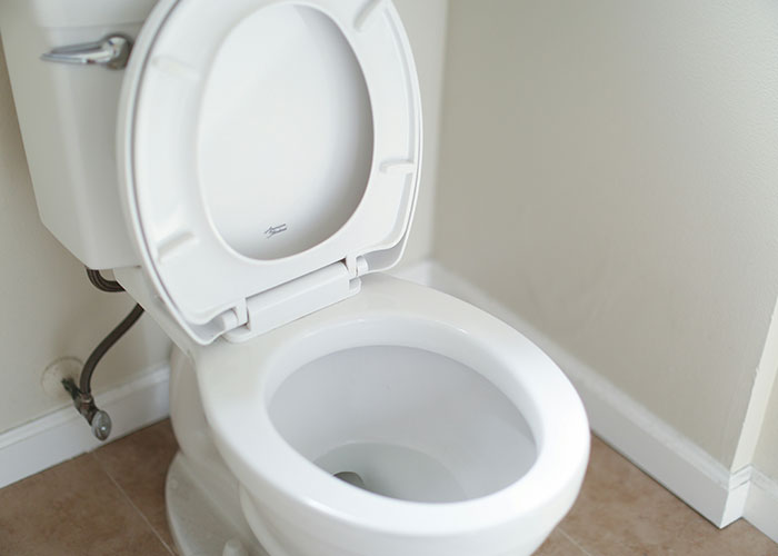 White toilet bowl with open lid in a clean bathroom, illustrating signs someone is cheating and you're not just paranoid.