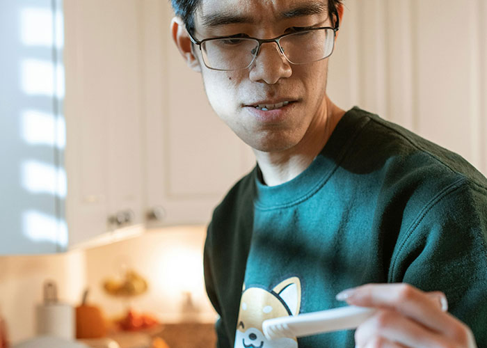 Man in glasses looking worried while holding a pregnancy test, illustrating signs that someone is cheating.