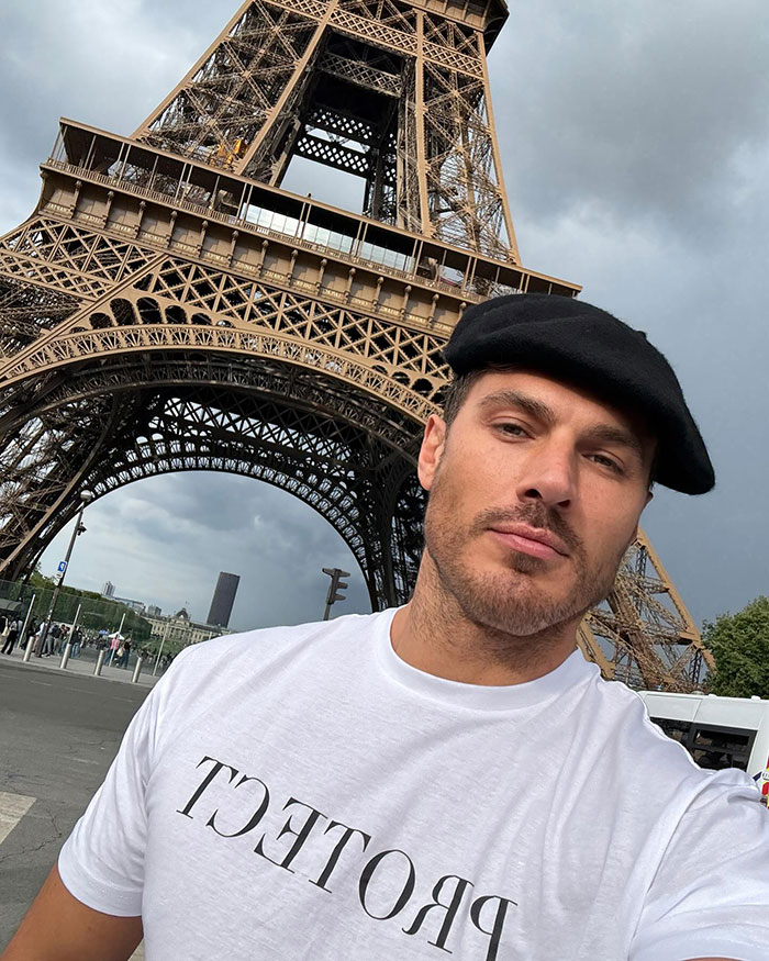 Man in a black beret and white shirt posing near the Eiffel Tower, unrelated to Kim Kardashian's hair stylist or Cannes bulge. Man in a black beret and white shirt posing near the Eiffel Tower, unrelated to Kim Kardashian's hair stylist or Cannes bulge.