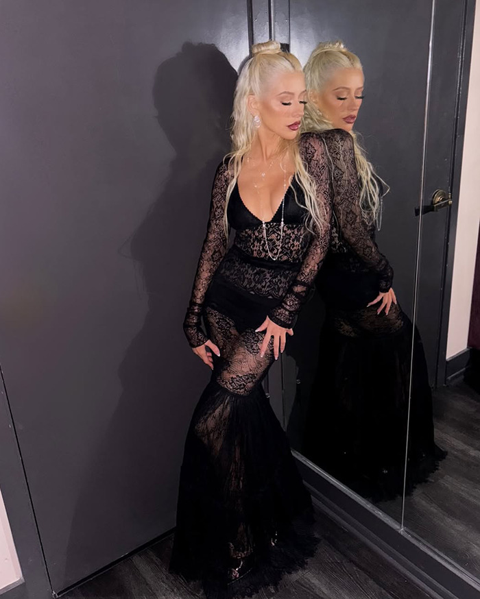 Christina Aguilera in a black lace dress posing by a mirror, fueling Ozempic and surgery rumors. Christina Aguilera in a black lace dress posing by a mirror, fueling Ozempic and surgery rumors.