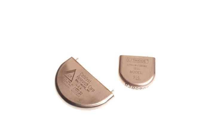 Two vintage CIA spy technology devices, small metal components used for covert operations and intelligence gathering.