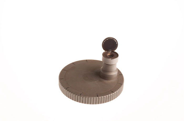 Small round CIA spy technology device with a raised cylindrical lens, showcasing innovative espionage equipment.