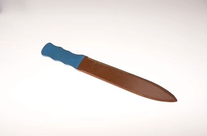 Spy knife with blue handle and brown blade sheath representing CIA spy technology examples of human ingenuity.