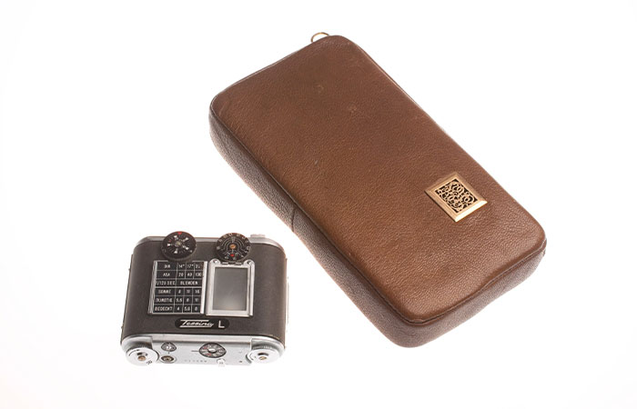 Vintage CIA spy technology camera with brown leather case, showcasing inventive design and advanced surveillance ingenuity.