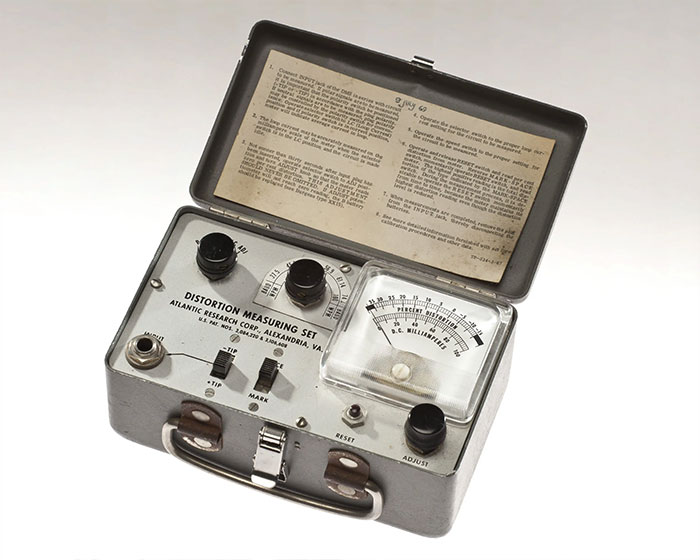 Vintage CIA spy technology distortion measuring set with analog meter in metal case, illustrating early espionage ingenuity.