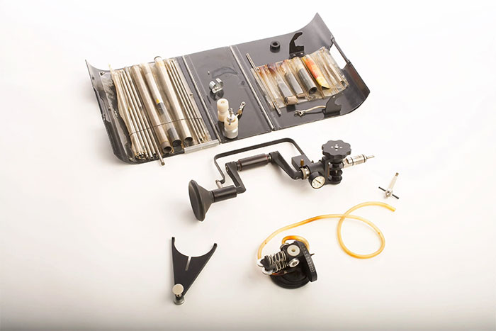 Vintage CIA spy technology equipment laid out on a white surface showcasing classic espionage tools and ingenuity.