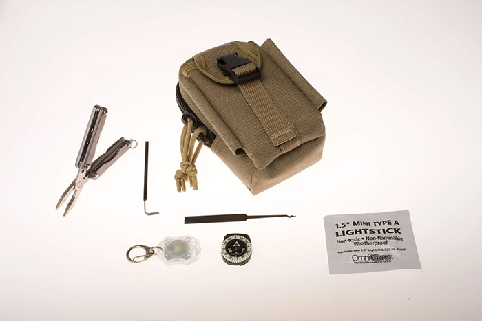 Compact CIA spy technology kit with multitool, compass, lockpicks, lightstick, and tactical pouch showcasing human ingenuity.