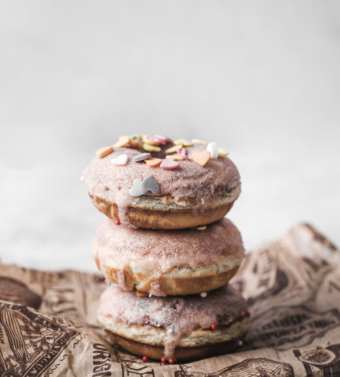 Three stacked sprinkled donuts with pink icing, representing weirdest ways to earn quick money.