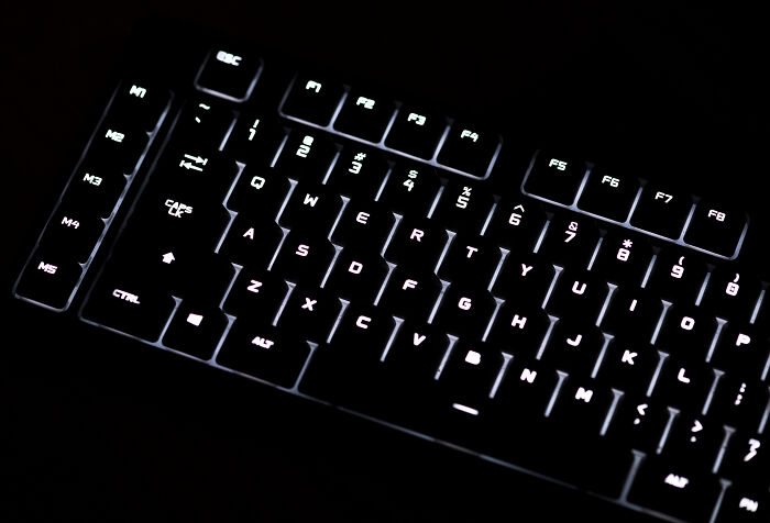 Backlit mechanical keyboard in low light showing illuminated keys with appalling facts people unaware concept.