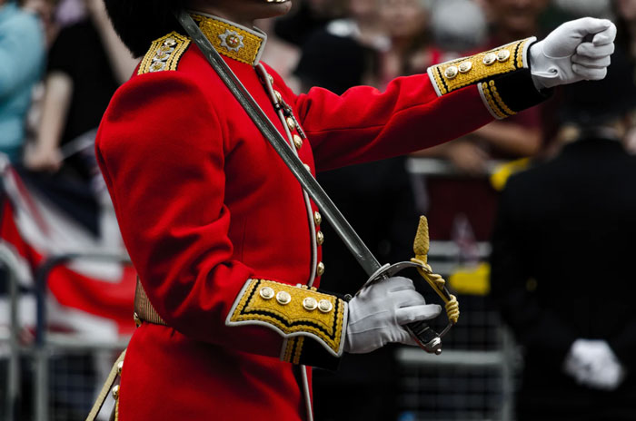 Soldier in traditional red uniform holding a sword, representing national stereotypes that are hilarious and might be true.