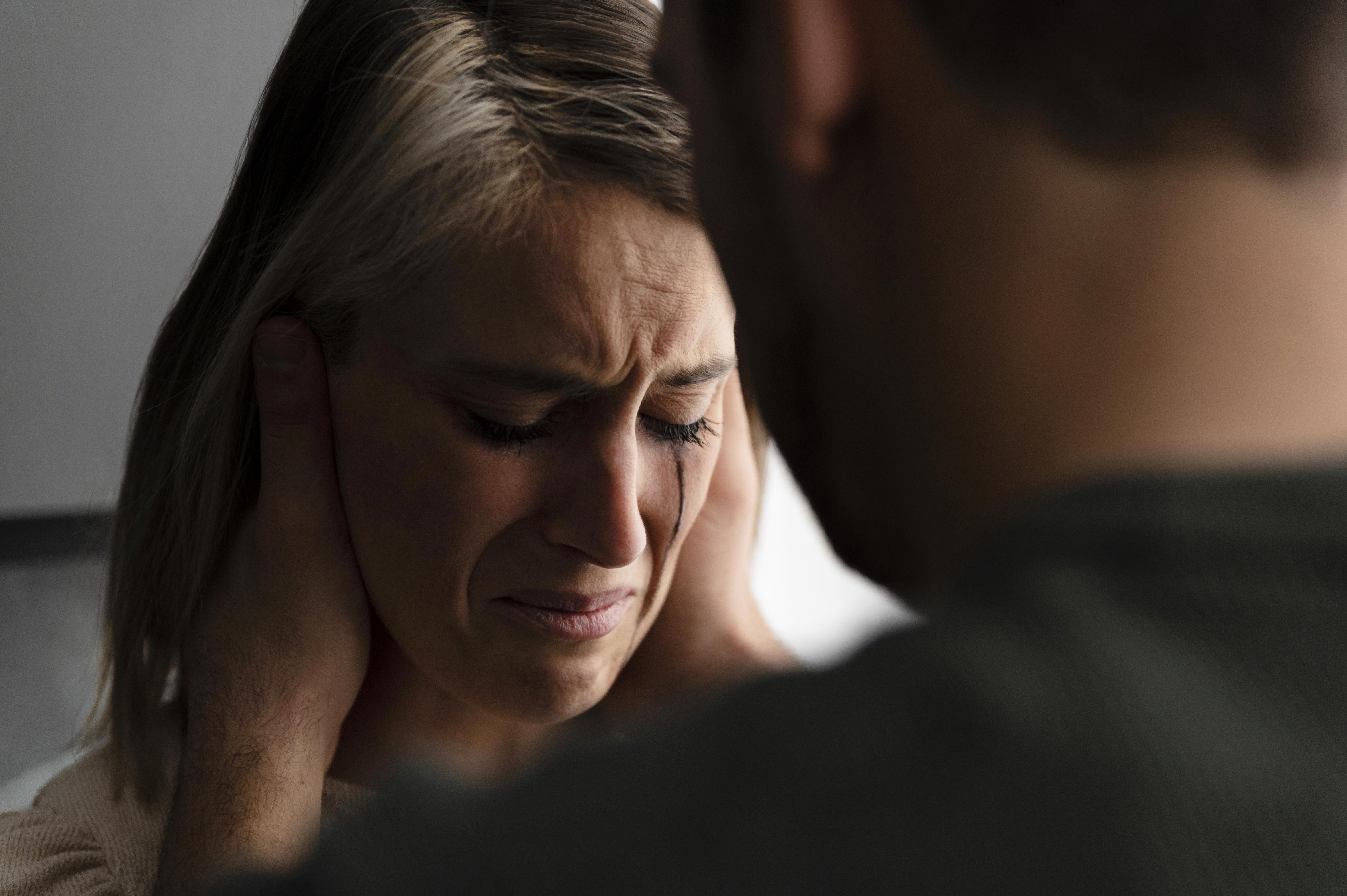 Woman crying with tears streaming, comforted by her husband, reflecting a heartbreaking cancer diagnosis moment.