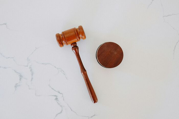 Wooden judge gavel and sound block on a white marble surface related to Diddy's ex-assistant testimony topic.