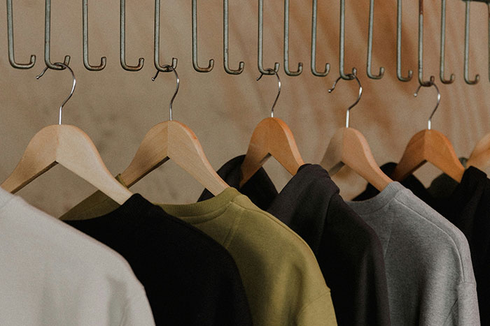 Clothes hanging on wooden hangers inside a stranger's home reflecting unforgettable things seen by workers.