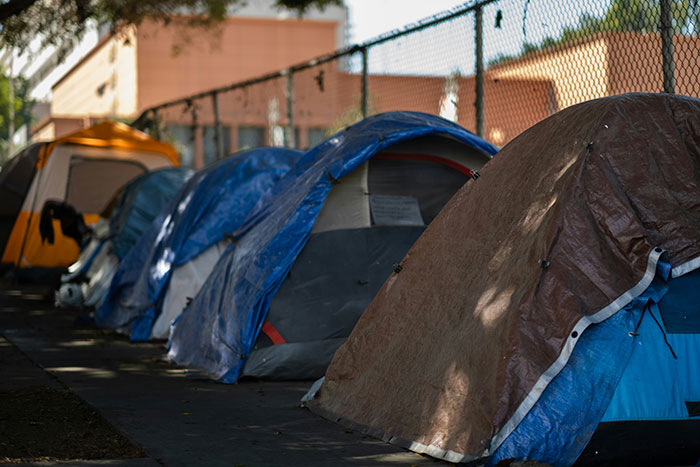 Row of tents along a city sidewalk illustrating mind-blowing cultural differences in urban living and homelessness awareness.