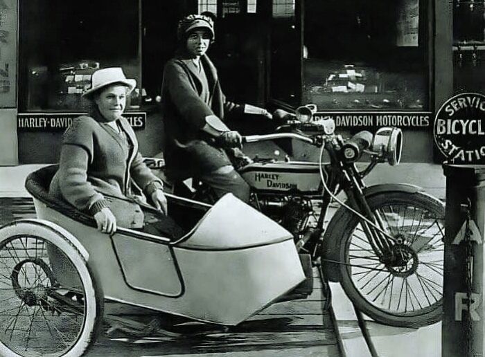 Vintage Harley Davidson motorcycle with sidecar carrying two women, illustrating unusual and interesting facts from history.
