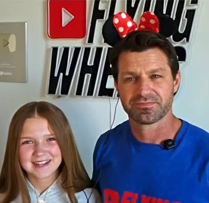 Man wearing Minnie Mouse ears and a girl sparking debate over price of one-day family trip to Disney World. Man wearing Minnie Mouse ears and a girl sparking debate over price of one-day family trip to Disney World.