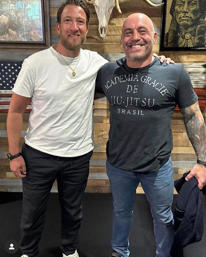 Dave Portnoy standing with a friend in casual clothes, smiling, reflecting on his net worth and fortune changes.