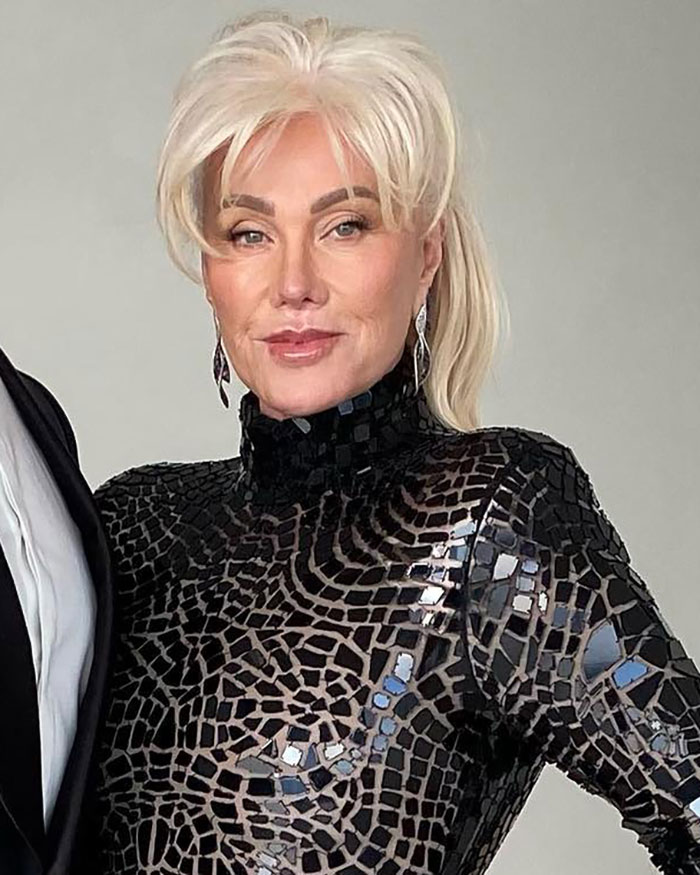 Woman with platinum blonde hair wearing a black patterned dress, related to Hugh Jackman divorce and aging wife discussion. Woman with platinum blonde hair wearing a black patterned dress, related to Hugh Jackman divorce and aging wife discussion.