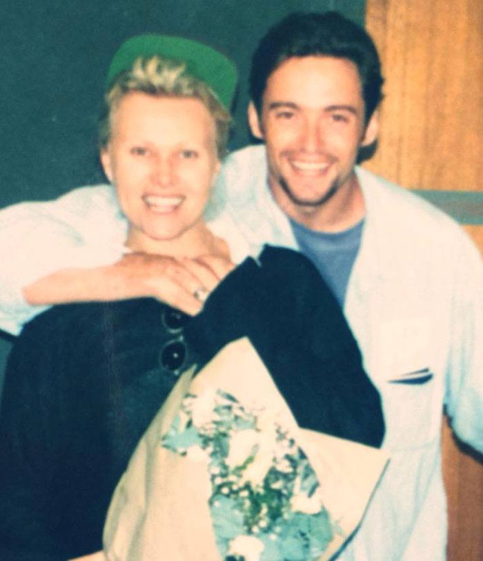Deborra-Lee Furness and Hugh Jackman smiling together, holding flowers during a candid moment in their journey of betrayal.