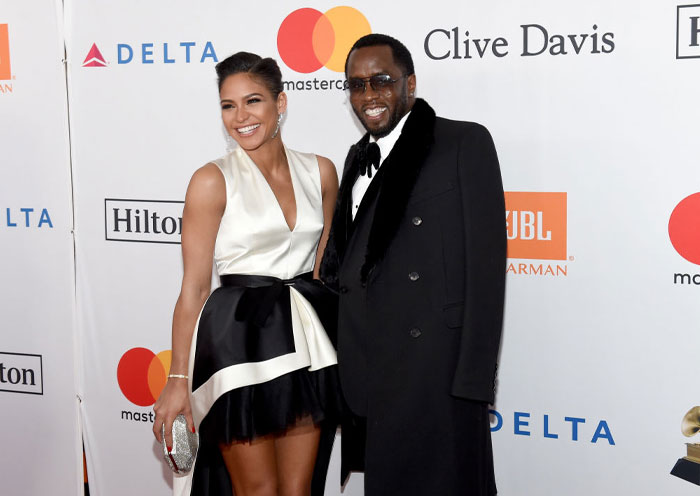 Diddy and a female companion smiling on the red carpet, highlighting Diddy&rsquo;s net worth and legal trouble impact.