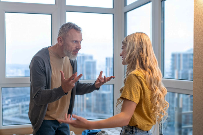 Man and woman arguing intensely in a modern apartment, depicting cousin betrayed lady having affair with her ex conflict.