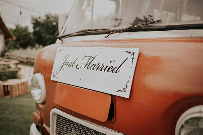 Vintage orange car with a just married sign highlighting a wedding theme related to maid of honor missing sister&rsquo;s wedding.