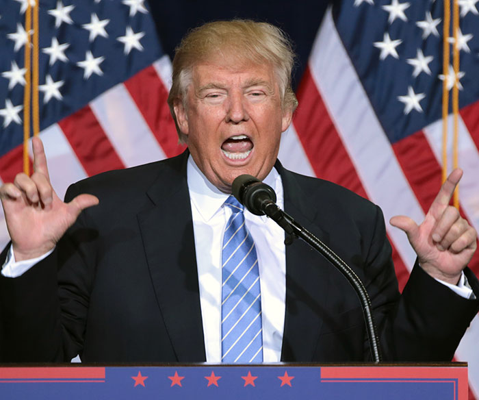 Donald Trump speaking at a podium with American flags behind, reacting to comments on Taylor Swift and White House response.