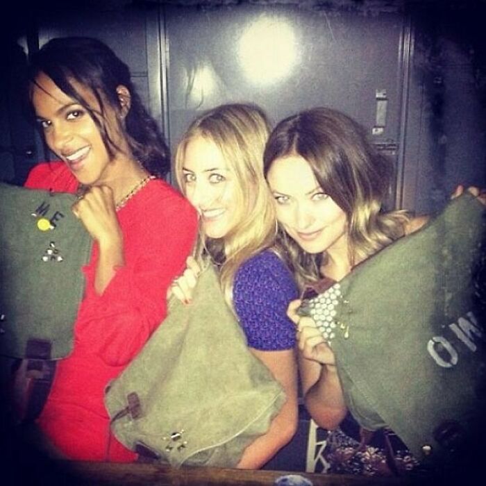 Three celebrities smiling and holding green bags in a vintage Instagram posts photo from way back in the day.