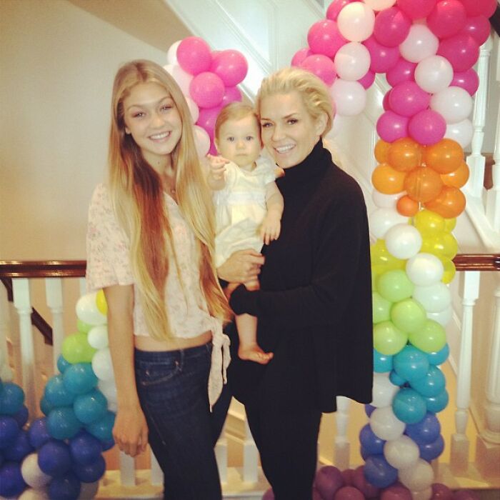 Two women and a baby smiling indoors with colorful balloon decorations, capturing a nostalgic celebrity Instagram moment.