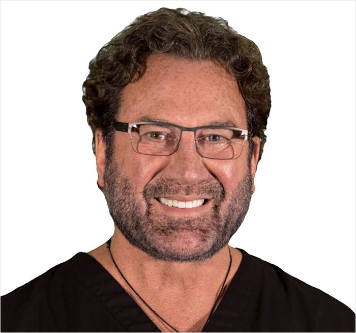 Male plastic surgeon wearing glasses and black scrubs, smiling against a white background, related to women disfigured cases.