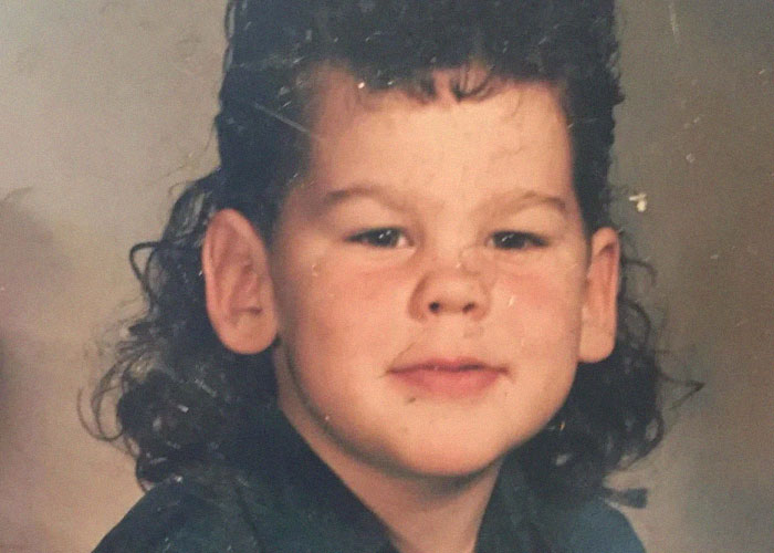 Young boy with a classic 80s mullet hairstyle representing a dumb fad participated in the past.